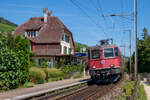 Die Re 4/4  11299 fährt mit einem Fanzug aus Basel durch Ligerz Richtung Genf. 11.8.2024