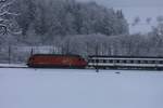 Eine Re 460 ist am 27.01.2021 mit EW IV im Winter bei Tecknau BL unterwegs Richtung Olten.