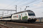 Re 460 035-9, mit einer Helvetia Werbung , durchfährt den Bahnhof Muttenz. Die Aufnahme stammt vom 23.03.2016.