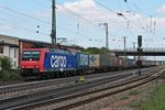 Ausfahrt am 18.04.2015 von Re 482 025-4 mit einem Containerzug aus dem Überholgleis in Müllheim (Baden) gen Süden.