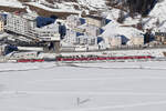 RhB  mit der Ge 4/4 III 642  INTEGRAL  bei Samedan am 17.1.2025. Im Hintergrund das Krankenhaus, hier ist gerade der Heli der REGA AW109 auf dem Dach gelandet.