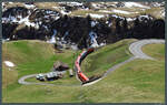 HGe 4/4 II Nr. 4 der MGB taucht mit dem Glacier-Express aus einem der Kehrtunnel bei Andermatt auf. (19.04.2022)