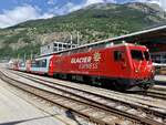 Glacier Express 902 mit der HGe 4/4 '' 4  Täschhorn  am 23.6.21 beim Bahnhof Brig.