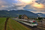 Der SOB Triebwagen RBDe 561 081 fährt zusammen mit der Schublokomotive Re 446 016 mit dem VAE sehr frühs bei Aprilstimmung,jedoch am 13.7.2016 in Kaltbrunn vorüber.