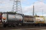 Verschiedene Tankcontainer mit unterschiedlichen Gefahrgütern auf Sgns, eingereiht in einen abgestellten Chemikalienzug bei Köln-Eifeltor am 06.10.2015.