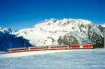 MGB FO-DIENSTZUG 6821 von Oberalppass-Calmot nach Andermatt am 15.02.1998 etwa 400m unterhalb von Ntschen mit Steuerwagen voraus ABt 4155 - B 4255 - B 4276 - Zahnrad-Gepcktriebwagen BDeh 4/4I 55. Hinweis: Fahrzeuge noch in alter Lackierung. Der abgelichtete Dienstzug ist die Rckleistung eines Wintersportzuges der die Wintersportgebiete Ntschen und Oberalppass von Andermatt aus bedient. Der Zug schlngelt sich hier bremsend in einen 4193m langen Zahnstangenabschitt mit 110 Promille Geflle in mehreren Serpentinen von Ntschen nach Andermatt im Urserental hinab. Auch am spten Vormittag ist im ganzen Tal noch Schatten bis zum 2431m hohen Furkapass, der ber der Triebwagenspitze erkennbar ist. 
