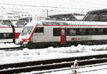 Ausfahrt eines IC mit dem Steuerwagen an der Spitze aus dem Bahnhof Zürich HB im Schneetreiben.