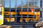 Tor zur gemeinsamen Postauto/RHB Werkstätte in Heiden. Während sich der Doppelstockbus in den Scheiben spiegelt, erkennt man in der Halle den TW BDeh 3/6, der wegen Revision aufgebockt ist. (28.12.2015)