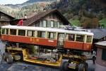 BLM Bergbahn Lauterbrunnen-Mürren: CFe 2/4 11 (SIG/MFO 1913), Transport Winteregg-Lauterbrunnen mit dem Spezialfahrzeug  Castor und Pollux , Isenfluhstrasse, Lauterbrunnen, 24. Oktober 2024. Der Wagenkasten ist in dieser Kurve zentimergenau an vorstehenden Hausdächern vorbei zu manöverieren.