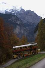 BLM Bergbahn Lauterbrunnen-Mürren: CFe 2/4 11 (SIG/MFO 1913), Taltransport Winteregg-Lauterbrunnen mit dem Spezialfahrzeug  Castor und Pollux , unterhalb Alpweg, Lauterbrunnen, 24. Oktober 2024. Der Blick führt ins Lauterbrunnental. Erkennbar ist das Seil der Luftseilbahn Lauterbrunnen-Grütschalp. Der knapp zweihundert Meter tiefer liegende Talboden mit Lauterbrunnen ist nicht einsehbar.