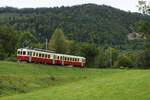 CJ La Traction Chemins de fer du Jura: Ct4 702 + CFe 4/4 601 ( train des horlogers ), Vormittagszug Pré-Petitjean-Glovelier, Foradrai, 8. September 2024. In der grossen Kurve beim Weiler Foradrai dreht die Trasse in stetigem Gefälle taleinwärts. Der Zug fährt hier hinunter in die Combe Tabeillon und erreicht deren Talboden in der Station Combe-Tabeillon (Spitzkehre). Danach führt die Fahrt an der linken Talflanke im Gefälle wieder talauswärts hinunter nach Glovelier. 