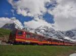 Vor dem Massiv des 3970 m hohen Eigers mit der wolkenverhangenen Spitze der Eigernordwand und des 4107 m hohen Mnchs befindet sich der 2002 in Betrieb genommene Triebwagen 218 kurz vor der Einfahrt in den Ziel- und Endbahnhof Kleine Scheidegg.