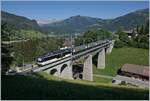 Ein MOB GoldenPass Zug von Zweisimmen nach Montreux mit einen schiebenden Alpina Be 4/4 Serie 9000 fährt bei Gstaad über den 109 Meter langen Grubenbachviadukt.