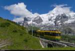 Der WAB Pano 146 fährt am 24. Juni 2015 etwas oberhalb der Wengernalp talwärts. Im Hintergrund die von Wolken verdeckten Eiger und Mönch.