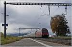 Ein SBB Re 460 fährt mit ihrem langen IC durch den Bahnhof von Oron und der Blick gegen Süden zeigt, dass dem Föhn bald die Puste ausgeht.