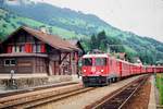 01.08.1991, Schweiz, Abendlicher Besuch auf dem Bahnhof Trun, ein Zug der RhB mit Lok 619 fhrt ein.