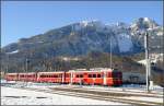 Be 4/4 512 verlsst vor prchtiger Winterkulisse die Haltestelle Ems Werk Richtung Chur.