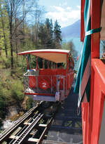 Auf der Fahrt mit der Giessbachbahn, gerade bei der Ausweiche mit Gegenzug. Neben dem Zugseil unten deutlich zu sehen ist die Zahnstange System Riggenbach, die als Bremse dient. Im Hintergrund der Brienzersee. Aufnahme vom 13. April 2017