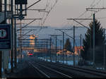 Der Bahnhof Kiesen liegt bereits im Schatten, das Getreidesilo in Wichtrach und die Strecke zwischen den zwei Orten, welche soeben von einem IC nach Interlaken befahren wird, werden aber noch von der Abendsonne beschienen. Aufgenommen am 3. Januar 2017.