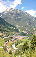 Blick über die untere und mittlere Ebene in Wassen: Während auf der mittleren Ebene soeben ein Interregio mit Ziel Locarno den Bahnhof Wassen durchfährt, ist auf der unteren Ebene ein