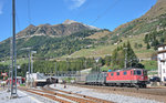 Gerade eben dem Gotthardtunnel entschwunden sind die Re 4/4 II 11345 und die grüne Re 6/6 11663 mit einem Containerzug.