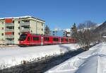 Der Winterwanderweg zwischen Davos Dorf und Davos Platz führt neben einem idyllischen Fluss den Gleisen der RhB entlang. Regio zwischen Davos Dorf und Davos Platz in der Wintersonne. Davos, 25.12.2024 