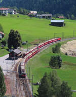 Der RegioExpress von Chur nach Disentis (unten) ist in Rabius-Surrein eingefahren. Der RegioExpress von Disentis nach Chur verlässt die Station, damit der Fahrgastwechsel stattfinden kann. Rabius, 31.7.2023