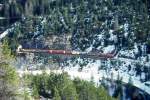 RhB Gterzug 5533 von Landquart nach St.Moritz am 03.03.1998 Ausfahrt Fuegna-Tunnel zwischen Muot und Preda mit E-Lok Ge 6/6II 701 - Haikv - Gbkv 5606 - Rw - Rw - Haikv - Haikv 5135 - Kk. Hinweis: gescanntes Dia
