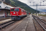 Die Ge 6/6 II 707 fährt mit einem, mit Betonteilen und Müllcontainern beladen Güterzug, in den Bahnhof Bever ein.