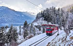 Wenige Sekunden nachdem die Sonne sich verabschiedet hat,taucht die Ge 4/4 III 647 mit einem Re nach St.Moritz auf der Schmittentobelbrücke auf.Bild 15.12.2017