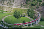 Der bereits im vorherigen Bild zu sehende Regio St. Moritz - Tirano hat den Bernina Express am 12. Juli 2017 im Bahnhof Brusio gekreuzt und durchfährt jetzt den unterhalb des Dorfes gelegenen Kreisviadukt.