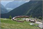 R1633 mit ABe 8/12 3503 fährt durch die Alp Grüm Kehre talwärts Richtung Lago di Poschiavo im Hintergrund und weiter bis Tirano (I). Der Seilbahnmast der Materialbahn dient zur Versorgung der Galeriebaustelle unterhalb Alp Grüm.  (19.06.2019)