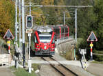 Gewöhnungsbedürftig: Das Signal zeigt 'Fahrt', obwohl der Zug aus der Gegenrichtung kommt! Triebzug 'Allegra' 3505 fährt mit dem Bernina-Express von Tirano nach Chur bergwärts zwischen Poschiavo und Cavaglia unterhalb der Dienststation Cadera über diesen Strassenübergang. Beim Hauptsignal 'E' dürfte es sich um ein so genanntes Deckungssignal handeln, welches nur den geschlossenen Zustand der Schlagbäume kontrolliert, aber nicht die Fahrrichtung des Zuges. Poschiavo, 22.10.2024