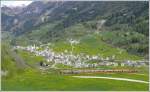 R1654 fhrt durch die frischen Blumenwiesen hoch ber dem Dorf San Carlo Richtung Berninapass. Beim linken Dorfausgang erkennt man die Passstrasse, die ab Poschiavo bis zur Passhhe einen vllig andern Weg als die Bahn einschlgt-zum Glck. (06.05.2009)