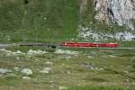 Regionalzug 1632 Tirano - St. Moritz am 31.7.2008 zwischen der Passhhe und Bernina-Lagalb. Hinter dem leuchtend roten Regionalzug mit Gem 4/4 802 und ABe 4/4 46 sind die vier leeren Holzwagen kaum zu erkennen... 