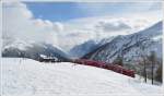 R1633 mit ABe 8/12 3503  Carlo Janka  mit Oelzisternen und Rundholzwagen in der Alp Grm Kurve. Unten im Tal schimmert der Lago di Poschiavo. (22.02.2011)