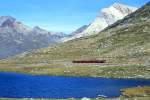RhB Regionalzug 454 von Tirano nach St.Moritz am 30.08.1993 am Lago Nero zwischen Ospizio Bernina und Bernina Lagalb mit Triebwagen ABe 4/4 III 51 - AB 154x - 4x B - DZ. Hinweis: der See hat seinen Namen von der dunklen Frbung bei blauen Himmel, Wasserspiegel 2223m .NN, gescanntes Dia.
