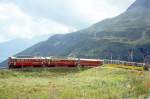 RhB Aussichtswagen-Extrazug 3962 fr RHTIA TOURS von Alp Grm nach Pontresina am 30.08.1996 in der Einfahrtskurve Alp Grm mit Triebwagen ABe 4/4 I 34 - ABe 4/4 I 30 - D 4035 - B 2093 - B 2097. Hinweis: Die beiden Triebwagen sind inzwischen in gelb umlackiert, Kurve ist umgebaut mit 4-Schienengleis und Innenmasten in der Kurve, Steigung 70 Promille, Kurven-Radius 45m.
