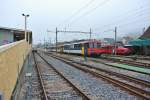 Der RBe 206 Pendel beim Wenden als Regio im Bahnhof Balsthal, rechts daneben steht der Rote Pfeil der OeBB. Wegen Bauarbeiten ist der eigentliche Zugang zum Perron gesperrt, desshalb wurde ein provisorischer Steg errichtet (Standort des Fotografen auf dem Steg), 18.11.2013.