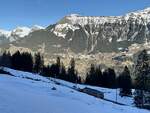 Der Be 4/4 22 der im Schatten nach Mürren fährt, während man auf der anderen Bergseite in Wengen noch die Sonne geniessen kann, am 28.1.24 zwischen Grütschalp und Winteregg.