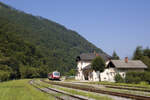 Am 9. Juli 2024 hat 814 123 + 813 123 soeben als LP 4202 (Sežana - Jesenice) den Bahnhof Grahovo erreicht und wartet geduldig auf die Ankunft des Gegenzugs, während der Fahrdienstleiter gerade den Schranken schließt.