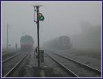 Morgennebel in Kidricevo am 12.10.2006. Triebwagen 814-123 als Regionalzug 3802 von Marburg nach Murska Sobota wartet auf seine Weiterfahrt whrend 642-DE  mit ihrem Kesselwagenzug auf die Bedienungsfahrt in das nahe gelegene Aluminiumwerk wartet.