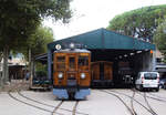 Ferrocarril de Sóller FS, Wagen Nr. 2, vor dem Lokschuppen im Bahnhof Sóller, 9.10.2013. Mit Blick frontal in den Lokschuppen. Rechts eine Schmalspurdraisine, die zu Wartungsarbeiten an der Strecke nach Palma eingesetzt wird.