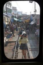 Blick durch die Stirnwandtüre des, als letztes Fahrzeug des ORD 4386 nach Ban Laem gereihten, NKF 1227 (1A' 2', dh, Fuji Heavy Industries, Bauj.1985) auf den Markt bei der Mae Klong Station am