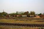 Ausgemusterte ต.ญ. (ต.ญ.=C.G./Covered Goods Wagon) und ข.ส. (ข.ส. =H.S./High Sided Wagon) warten abseits der Gleise in der Uttaradit Station auf ihr weiteres Schicksal. Bild vom 28.März 2023.
