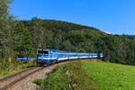 Kurz nach Verlassen des Bahnhofs Hojsova Stráž - Brčálník konnte ich die 754.064 mit dem R 775  Berounka  nach Praha hl.n. aufnehmen. Der Fünf-Wagen-Zug mit teilweiser Klimatisierung verlangt der  Taucherbrille  auf den Steigungen im Böhmerwald einiges ab. Ähnlich wie die Loks der Baureihe 218 bei den DB sind die markanten tschechischen Maschinen am Ende ihrer Nutzungsdauer angekommen und der Schadbestand ist hoch. 