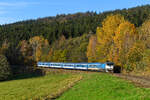 Am 27. Oktober 2024 zeigte sich der Herbst im Böhmerwald von der schönsten Seite. Bei Zelená Lhota trugen die Laubbäume noch ihre bunten Blätter und bildeten so den motivischen Rahmen für den von der 754.058 gezogenen R 768  Berounka  von Praha hl.n. nach Železná Ruda-Alžbětín. Farblich harmonieren die im ersten sogenannten  Najbrt -Farbschema gehaltene  Taucherbrille  und Wagenpark gut. Bemerkenswert ist, dass sich im Wagenpark des Schnellzuges neben modernen und modernisierten Fahrzeugen auch noch ein sogenannter UIC-Y-Wagen aus DDR-Produktion befindet.  