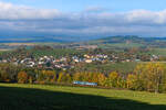 Ein kleiner Zug in den Weiten des Böhmerwalds. Bei Matějovice ergibt sich dieser Blick auf den Ort Dešenice und die hügelige Landschaft. Am 27. Oktober 2024 war eine typische Wetterlage für die Region zu beobachten, bei der sich die tieferen Lagen im Nebel befanden, wohingegen ab 500 Höhenmeter strahlender Sonnenschein herrschte. Der Regionova Triebzug 814.047 störte nur kurz die Ruhe, als er als Os 7549 von Železná Ruda-Alžbětín nach Klatovy die weiten Bögen hinabrollte, mit der die Strecke hier an Höhe gewinnt. Vollkommen unbemerkt von Eisenbahnfreunden haben sich mit Fahrplanwechsel auch diese Fahrzeuge aus dem Böhmerwald verabschiedet. Die Leistungen wurden von der Baureihe 847 übernommen. 