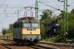 MAV Elektrolok V 431016 fährt im Bahnhof Veszprem am 2.9.2005 an dem  neben den Gleisen leicht erhöht stehenden Dampflok Denkmal der 3751931 vorbei.