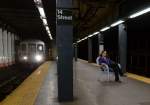 Praktisch: ungerührt nutzt diese Frau ihre Neuerwerbung(?)gleich mal als Sitzgelegenheit auf dem brütend heißen Bahnsteig der New Yorker Subway-Station  14th Street .